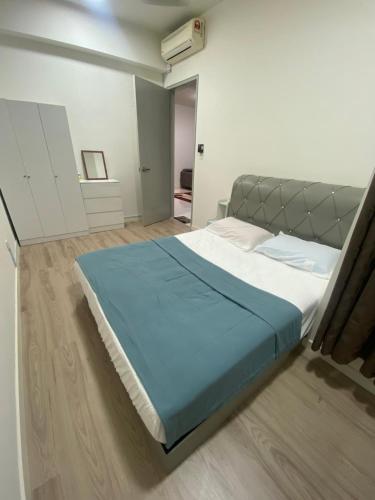 a bedroom with a large bed with a blue blanket at Homestay in Cheras