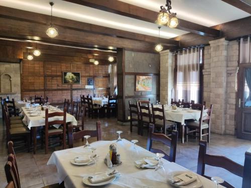 een eetkamer met tafels en stoelen in een restaurant bij DIMAL CASTLE in Poshnje