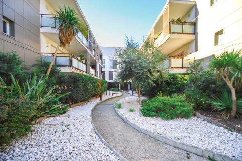 une passerelle dans la cour d'un immeuble dans l'établissement T2 Florescence Proche Montpellier Parking, à Castelnau-le-Lez