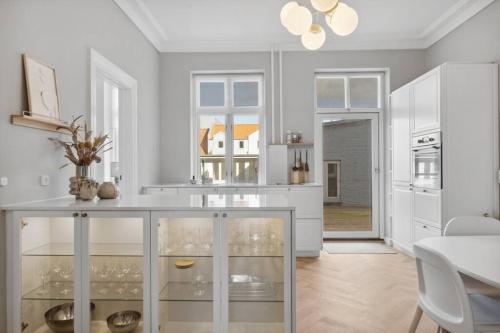 cocina con armarios blancos y comedor en City center apartment w/ large private balcony, en Aalborg