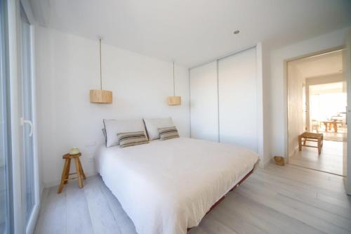 a white bedroom with a large white bed with two pillows at T3 Octopus Vue Mer Palavas Parking in Palavas-les-Flots