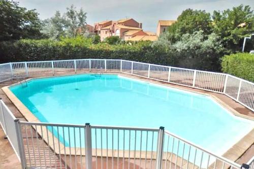 ein großer Pool mit einem Zaun um ihn herum in der Unterkunft T2 Tamaris Piscine Proche Plage Palavas in Palavas-les-Flots