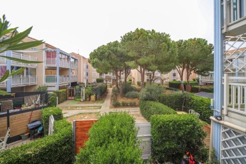 - une vue sur le jardin depuis un bâtiment dans l'établissement T2 Tamaris Piscine Proche Mer Palavas Parking, à Palavas-les-Flots