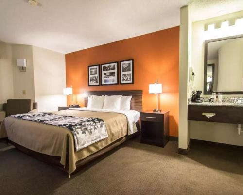 a hotel room with a bed and a sink at Sleep Inn -Daytona Beach I-95 Exit 268 in Ormond Beach