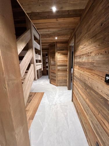 a room with wooden walls and a hallway with wooden shelves at Chalet Clémence in Taninges