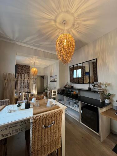 a kitchen with a large island and a chandelier at Hôtel de charme Equinoxe in Le Touquet-Paris-Plage