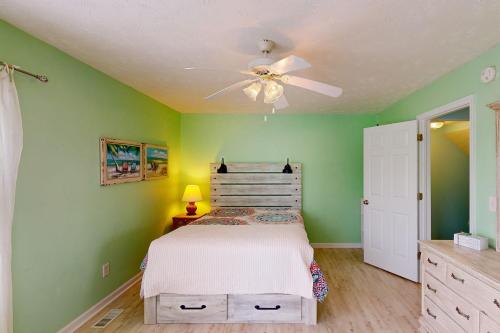 Schlafzimmer mit einem Bett und einem Deckenventilator in der Unterkunft Home by the Sea in Surf City