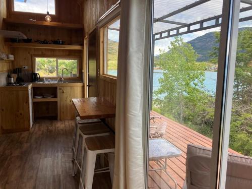 a kitchen with a table and a large window at Terra Luna Lodge in Puerto Guadal