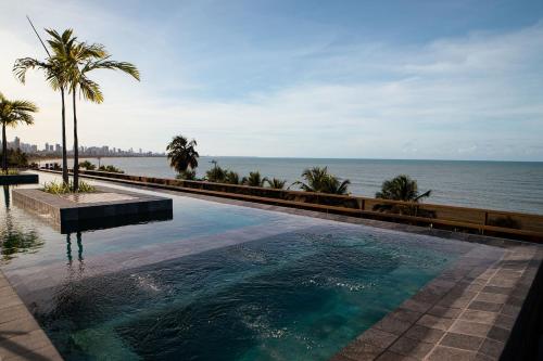 a swimming pool with a view of the ocean at Unity - Cabo Branco in João Pessoa