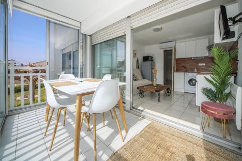 une salle à manger avec une table et des chaises sur un balcon dans l'établissement T2 Label Plage Piscine Proche Mer Parking Palavas, à Palavas-les-Flots