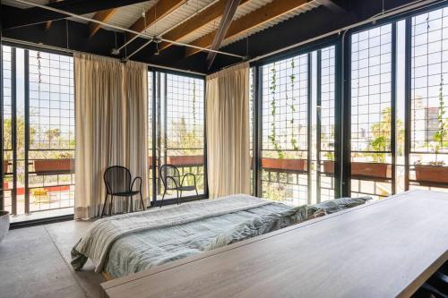 um quarto com uma cama grande e janelas grandes em Buenos Aires LOFT by Pardela, Colonia Americana em Guadalajara