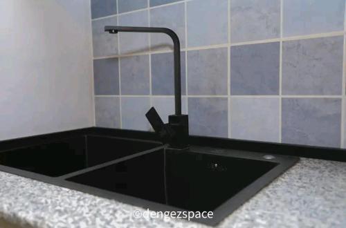 a black sink with a faucet in a kitchen at Royal Milk pipeline apartment in Addis Ababa
