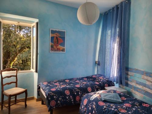 une chambre avec deux lits et une fenêtre dans l'établissement Chez Paulette - meublé de tourisme classé 3 étoiles, à Zonza