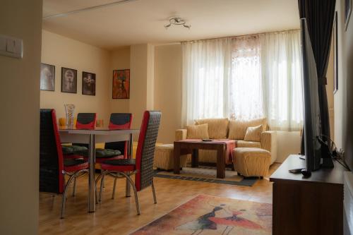 a living room with a table and a couch at Апартамент ДЕНИ in Pamporovo