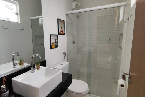 a bathroom with a sink and a toilet and a shower at Casa aconchegante, 1 suit e 2 quartos/escritório. in Petrolina