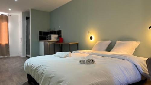 une chambre avec un grand lit blanc avec des serviettes dessus dans l'établissement Cocon Urbain - Arrivée autonome, à Tourcoing