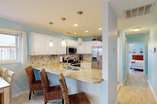 une cuisine avec des placards blancs et un comptoir dans l'établissement Home by the Sea, à Surf City