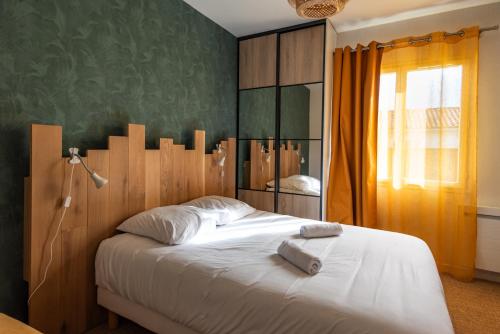 um quarto com uma cama branca e uma parede verde em Maison chaleureuse 3* à deux pas de la plage em Gujan-Mestras