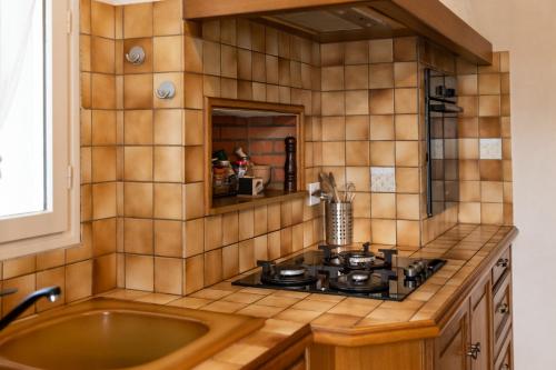 uma cozinha com um fogão e um lavatório em Maison chaleureuse 3* à deux pas de la plage em Gujan-Mestras