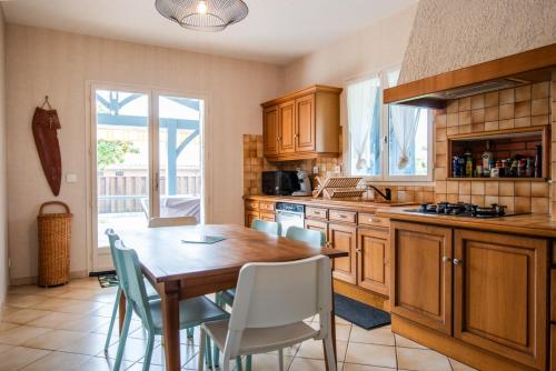une cuisine avec une table en bois et une salle à manger dans l'établissement Maison chaleureuse 3* à deux pas de la plage, à Gujan-Mestras