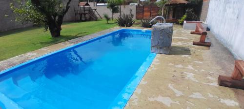 una piscina de agua azul en un patio en Mi Quincho Cañuelas en Cañuelas