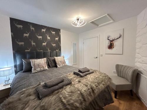 a bedroom with a large bed with a black headboard at Solway Cottage in Annan