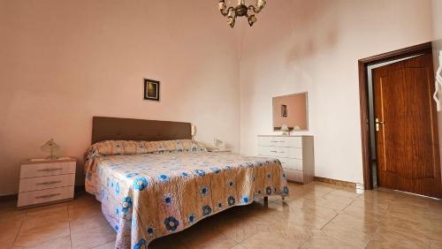 een slaapkamer met een bed, een dressoir en een deur bij Reggia di Poseidone in Taviano