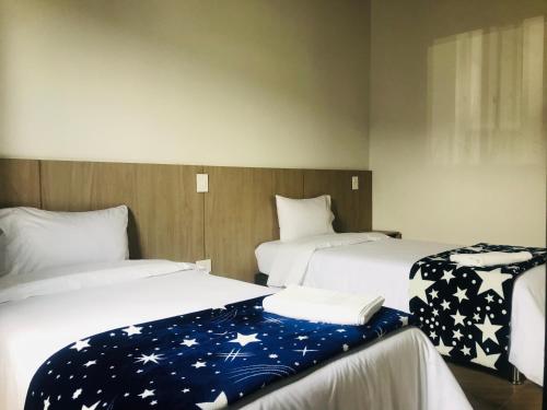 two beds in a hotel room with stars on them at Hotel & Golf Isak Aeropuerto in Rionegro