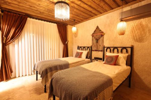 ein Hotelzimmer mit 2 Betten und einem Kronleuchter in der Unterkunft Alika Castle House in Uchisar