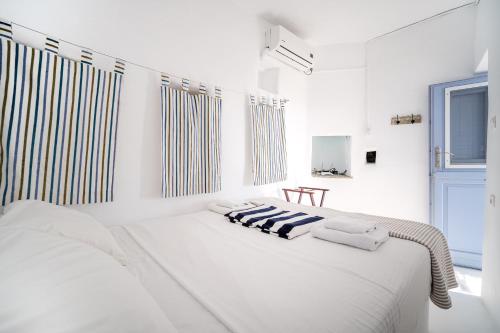 a white bedroom with a bed with two pillows on it at La Casa del Pastore in Serifos Chora