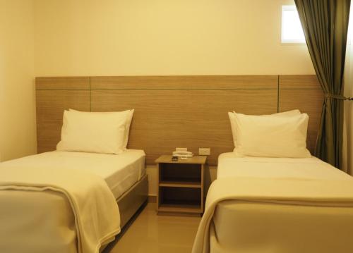 a hotel room with two beds and a table at Hotel Zamay Gaira in Santa Marta