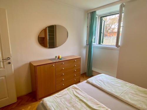 a bedroom with a bed and a dresser with a mirror at Apartment Simon - Old Stone Charm, Central Bol Life in Bol