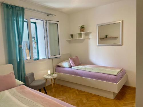 Cette petite chambre comprend 2 lits et une fenêtre. dans l'établissement Apartment Simon, à Bol