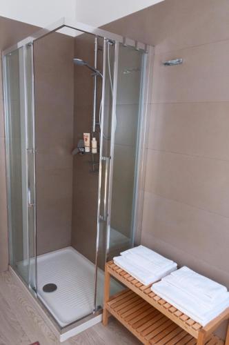 a shower with two white towels on a wooden bench at Novatek Apartment B&B in Chieti