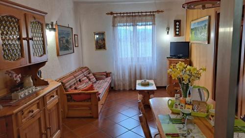 a kitchen and living room with a couch and a table at Casa Costa in Tonezza del Cimone