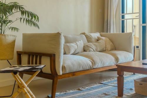 um sofá sentado numa sala de estar com uma mesa em The Greenleaf Apartment, Lubowa. em Kampala