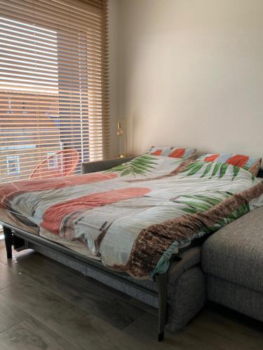 a large bed in a bedroom next to a window at Residentie Nivaria Zeebrugge, appartement met 1 slaapkamer aan de jachthaven in Zeebrugge