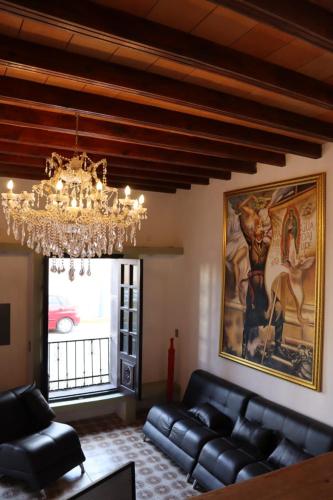 ein Wohnzimmer mit einem Sofa und einem Kronleuchter in der Unterkunft HOTEL CASA MEXICO in Dolores Hidalgo