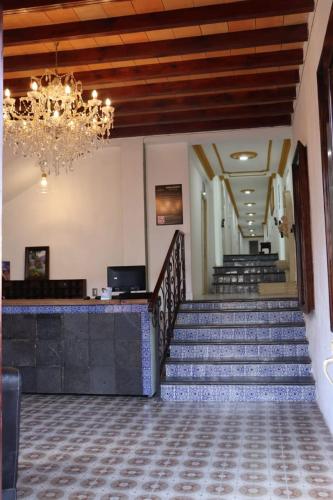 a lobby with stairs and a chandelier at HOTEL CASA MEXICO in Dolores Hidalgo