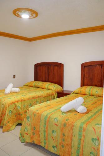 a bedroom with two beds with white comforters at HOTEL CASA MEXICO in Dolores Hidalgo