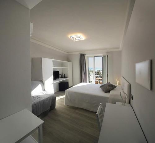 um quarto de hotel com duas camas e uma janela em Desideri em Numana