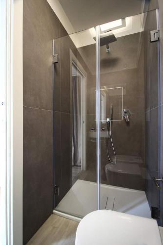 uma casa de banho com uma cabina de duche em vidro e um WC. em Desideri em Numana