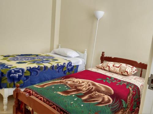 a bedroom with two beds and a bed with a mermaid blanket at LA CASA DE LA ABUELA in Barranca
