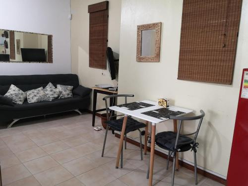 My lîl Place rental unit in a beach facing complex في فليك-إن-فلاك: غرفة معيشة مع طاولة وكراسي وأريكة