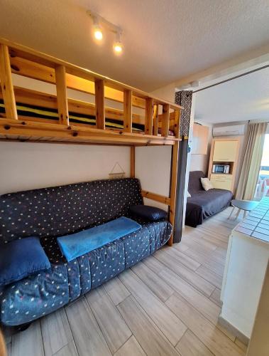 - un salon avec un canapé et des lits superposés dans l'établissement Cap d'Agde - Studio lumineux 2 - 4 personnes Terrasse avec vue, au Cap d'Agde
