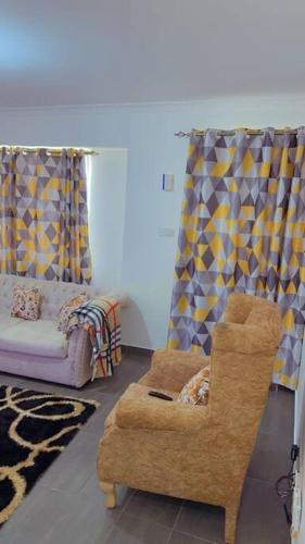een woonkamer met een stoel en een bank bij Nice cozy 1 bedroom apartment in Ruaka