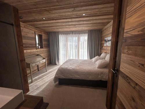 a bedroom with a bed and a desk in a room at Chalet Clémence in Taninges