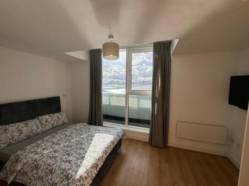 una camera con un letto e una grande finestra di Seaside Serenity Haven a Londra