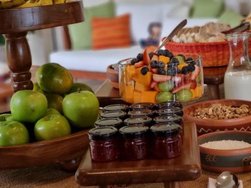 a table topped with a bowl of apples and a bowl of fruit at Sierra Sacred Valley in Urubamba