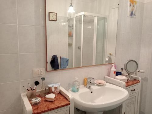 a white bathroom with a sink and a mirror at Alloggio turistico MARBO in Civitavecchia